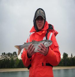Student researcher William Bernier holds a lake trout taken from Whitefish Bay, Lake Superior